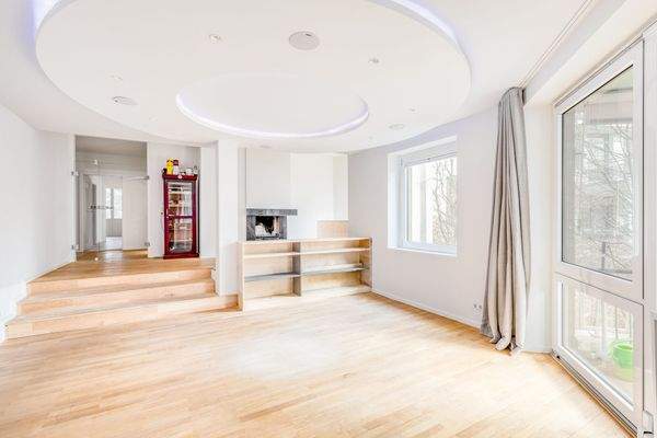 Repräsentativer Wohnbereich mit Podestebene, Kamin und bodentiefen Fenstern