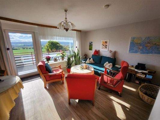 Wohnzimmer mit Zugang auf den Balkon OG