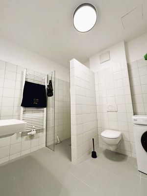 Modernes Badezimmer mit Waschmaschine und zweitem WC