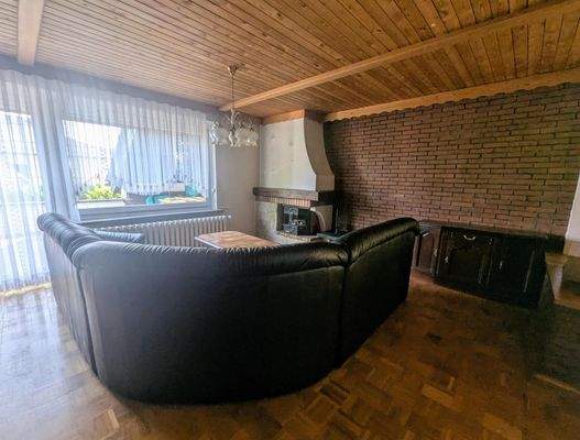 Wohnzimmer mit Kamin und Terrassenzugang