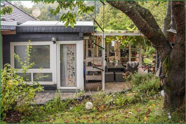 Blick vom Garten auf die überdachte Terrasse