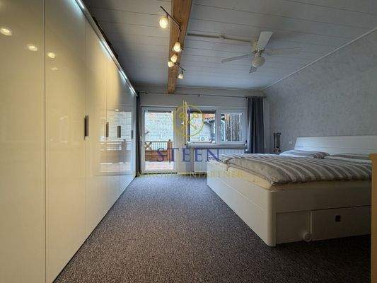 Schlafzimmer mit Tür zum Balkon