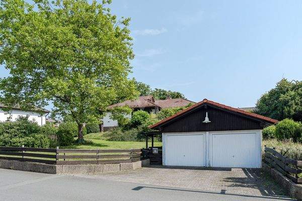 Straßenansicht mit Doppelgarage und Stellplätzen