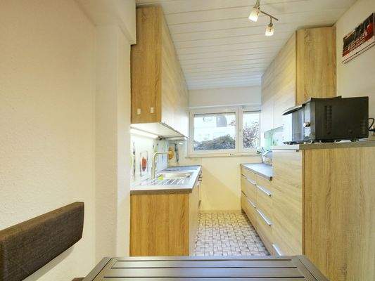 Schöne Einbauküche mit Blick zum Vorgarten und praktischem Essbereich