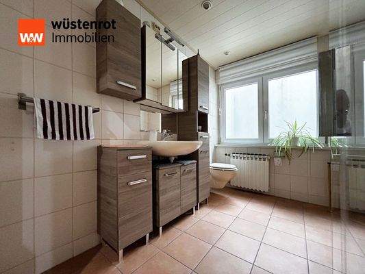 Einliegerwohnung: Klare Fliesen, warme Holzoptik – Badezimmer mit Struktur und Wärme