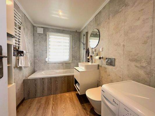 Badezimmer mit Badewanne, Fenster, WM-Anschluss und WC