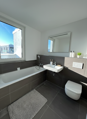 Tageslichtbadezimmer mit Badewanne und Dusche 