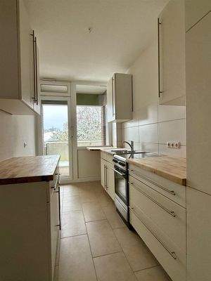 Küche mit Einbauküche und Zugang zum Balkon