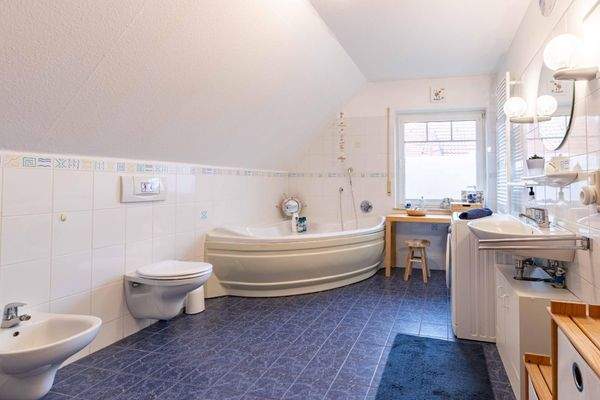 Großzügiges Badezimmer mit Eckbadewanne und Dusche im Obergeschoss