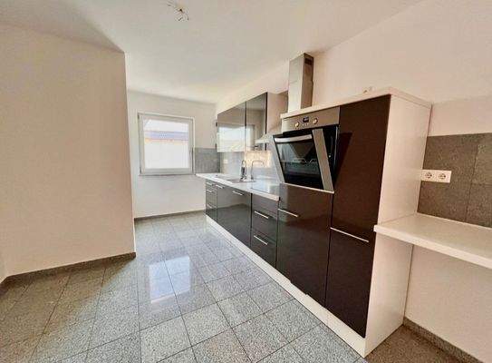 Moderne Küche mit integriertem Backofen und Dunstabzugsanlage