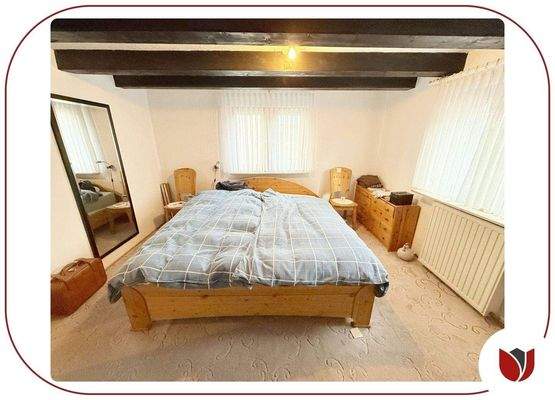 1. Schlafzimmer im 1. Obergeschoss mit Holzbalkend