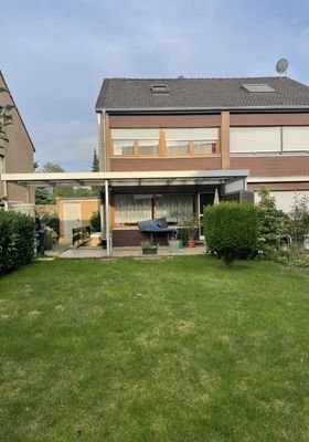 Rückansicht mit überdachter Terrasse und Garten