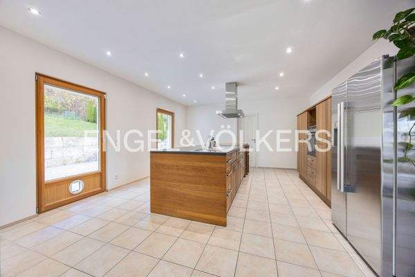 Großzügige, moderne Küche mit Kochinsel und direktem Zugang zum Garten und die angrenzende Speisekammer