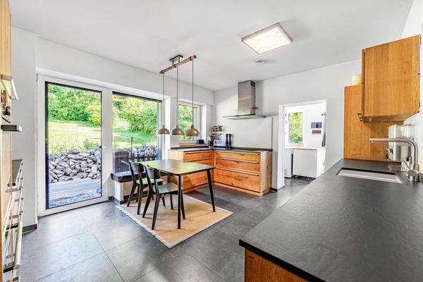 Großzügige Küche mit Gartenaustritt und angrenzendem Hauswirtschaftsraum im Erdgeschoss