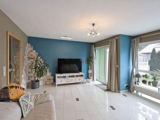 Schönes Wohnzimmer mit großen Fenstern zum Garten