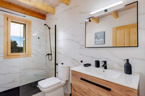 Badezimmer mit stilvollem Naturstein und bodenebener Dusche