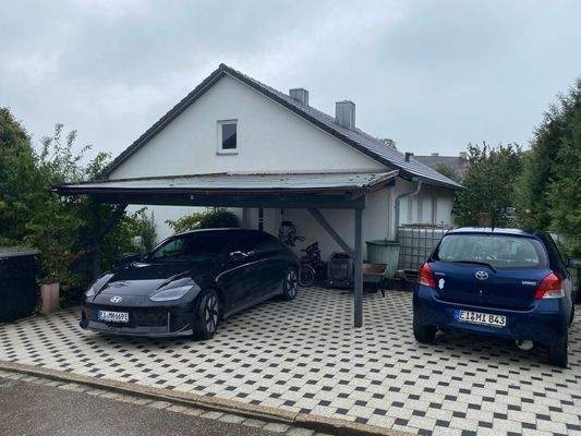 Auch einen überdachten Eingang, der zugleich als Carport dient und reichlich Stellfläche bietet. So kannst Du auch deine Einkäufe leicht ins Haus bringen. Das ganze auch noch zusätzlich zur Einzelgarage, die sich an der unteren Grundstücksgrenze befindet