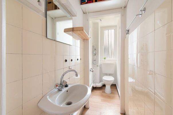 Sanitärbereich mit Waschbecken, WC und Tageslichtfenster