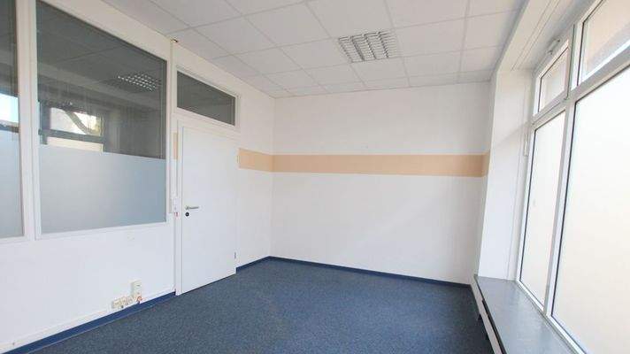 helles Bürozimmer mit einer großzügigen Fensterfront 