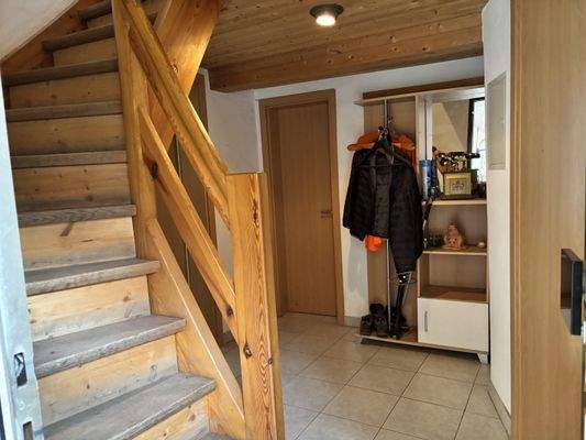 geflieste Eingangsdiele mit Holztreppe ins Obergeschoss