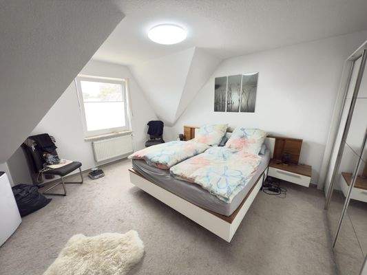 Schlafzimmer im Dachgeschoss mit Giebelfenster