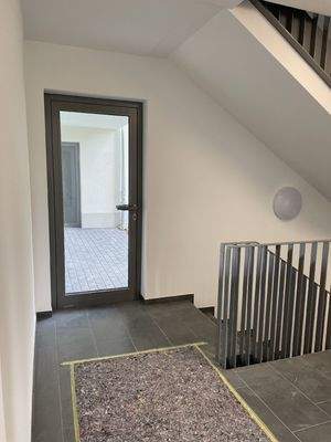 helles Treppenhaus mit Eingangstür