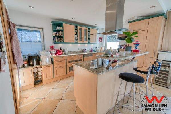 Küchenbereich mit Kochinsel und Theke im Erdgeschoss