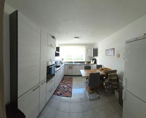 Großer Küchenbereich mit einer schönen Küchenzeile und integriertem Essplatz 