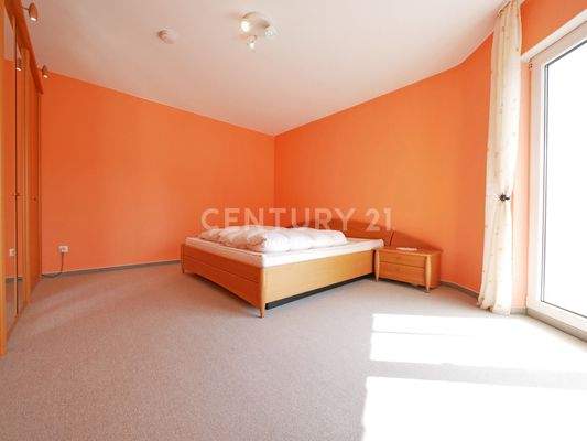 Schlafzimmer mit Balkon im Obergeschoss