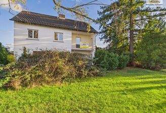 Rückansicht mit Balkon und viel Grün_2