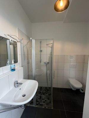 Badezimmer mit Dusche, WC und Fenster