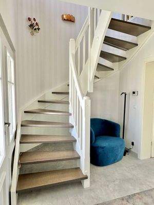 Die zweimal geviertelte Echtholztreppe führt elegant ins Obergeschoss