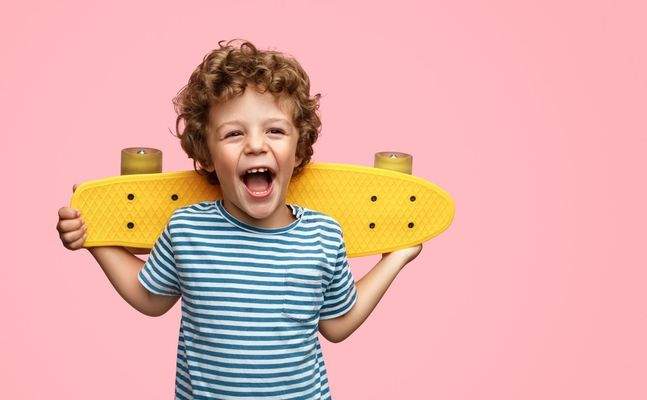 Junge mit Skateboard lachend