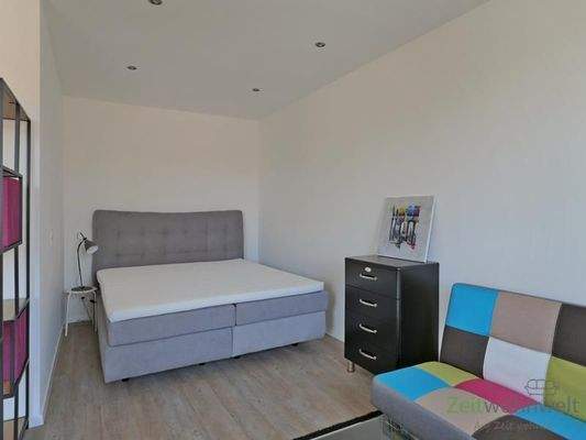 breites Bett hinter dem Raumteiler