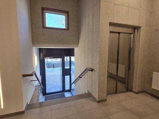 Treppenhaus mit Hauseingang und Fahrstuhl
