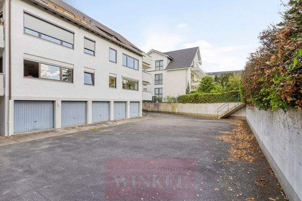 Hausrückseite mit Garagen und offenem Parkplatz