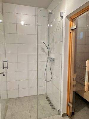 Großzügige Dusche mit Sauna im Erdgeschoss