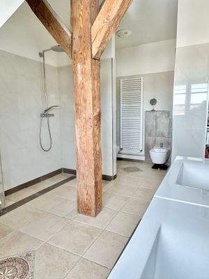 Ein Badezimmer  mit großer begehbahrer Dusche im Obergeschoss