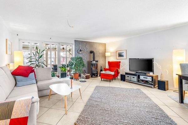 Wohnzimmer mit Kaminofen und Zugang zur Terrasse