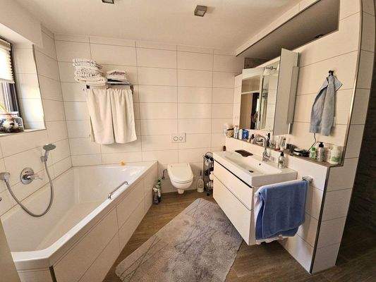 hell gefliestes Badezimmer mit Badewanne 