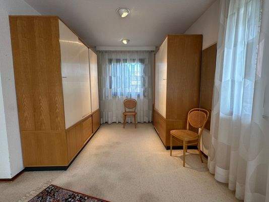 Im Schlafzimmer befindet sich ein eigener, freundlicher Ankleidebereich.