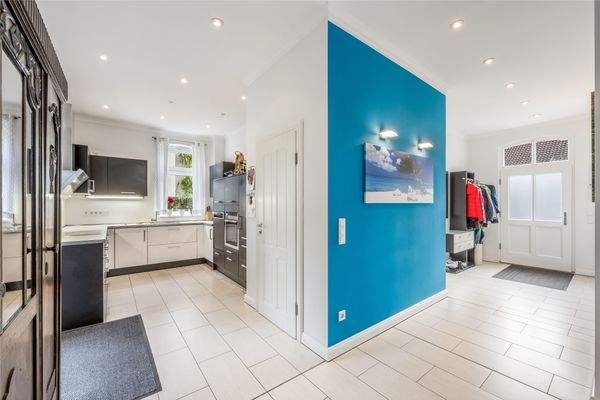 Eingangsbereich und offene Küche mit angeschlossenem Abstellraum