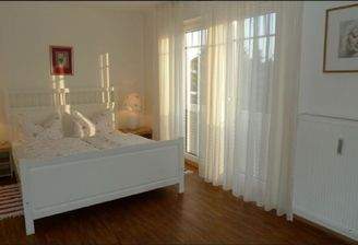 Helles Schlafzimmer mit großen Fenstern