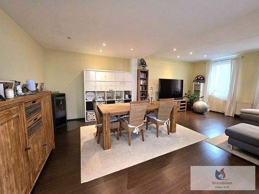 Wohn- Esszimmer mit Holzofen und vielen Fenstern