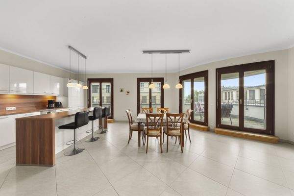 Die offene Küche mit großzügigen Fensterflächen zur umlaufenden Terrasse