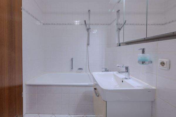 Badezimmer innenliegend mit Badewanne und Duschvorrichtung, WC