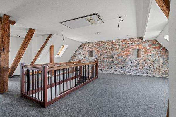 Raumansicht 2 mit historischer Natursteinwand und Holzbalken