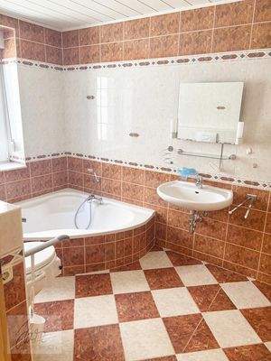 Wannenbadezimmer mit Fenster, Dusche und behindertengerechter Toilette