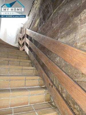 Treppenhaus mit offener Felswand rechts