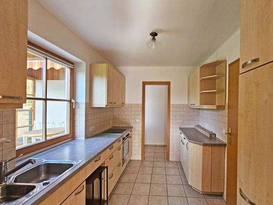 Küche von Essbereich gesehen mit Tür in Speis mit Außentür auf Terrasse